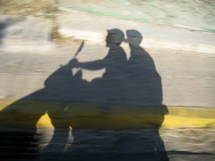 shadow image of two people on a scooter